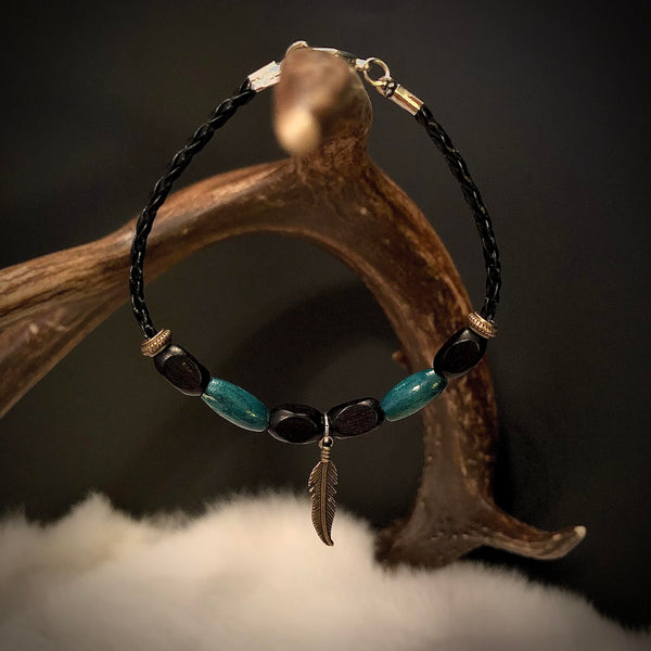 Bracelet 100% cuir tressé 8 1/2''( de long). Perles de bois, breloque plume bronze. (LIVRAISON INCLUSE DANS LE PRIX)