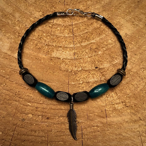 Bracelet 100% cuir tressé 8 1/2''( de long). Perles de bois, breloque plume bronze. (LIVRAISON INCLUSE DANS LE PRIX)